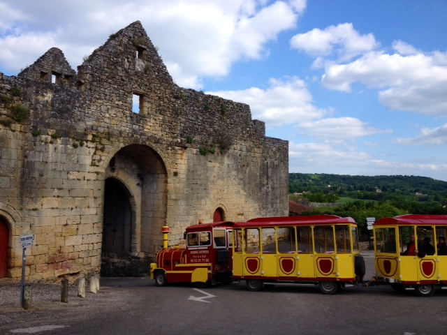 Le train touristique à la porte des Tours. - Domme