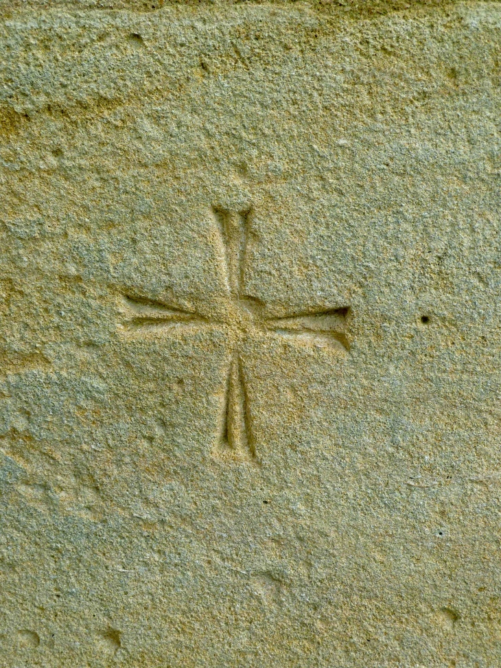 Détail : croix pattée, gravée sur la pierre du portail de l'église Saint-Martin. - Monbazillac