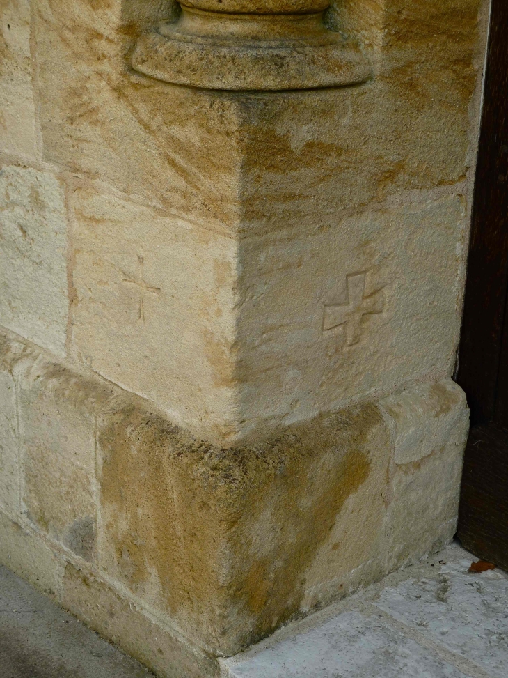 Croix pattées, gravées sur la pierre du portail de l'église Saint-Martin. - Monbazillac