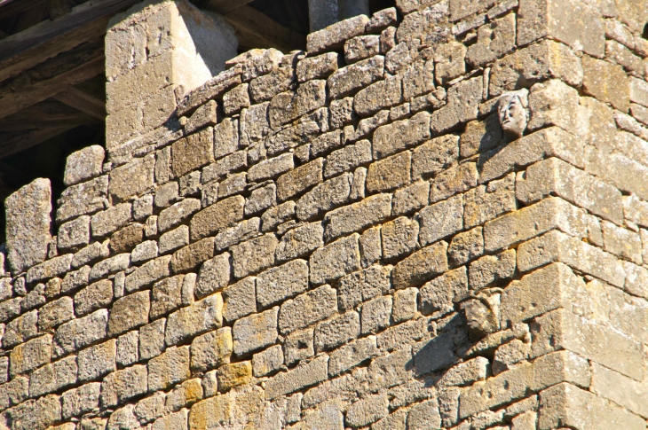 Têtes sculptées, incrustées dans le mur du clocher. Eglise de Saint Crépin. - Saint-Crépin-et-Carlucet