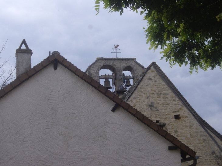 Le clocher et ses deux baies campanaires au dessus des toits. - Temple-Laguyon