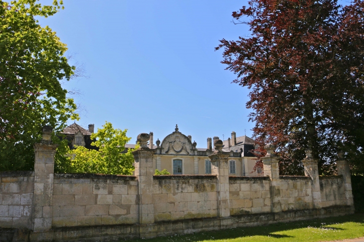 Façade est du château de Vendoire, derrière son mur de clôture.