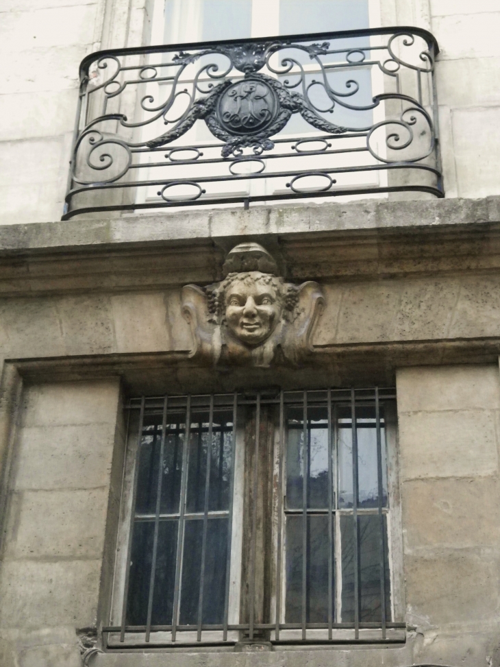 Mascaron et garde-corps de balcon en fer-forgé sur un immeuble ancien de la place Georges de Porto-Riche. - Bordeaux