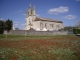 Photo suivante de Cazaugitat L'église 16/17ème derrière le terrain de foot fleuri de paquerettes et d'anémones rouges.