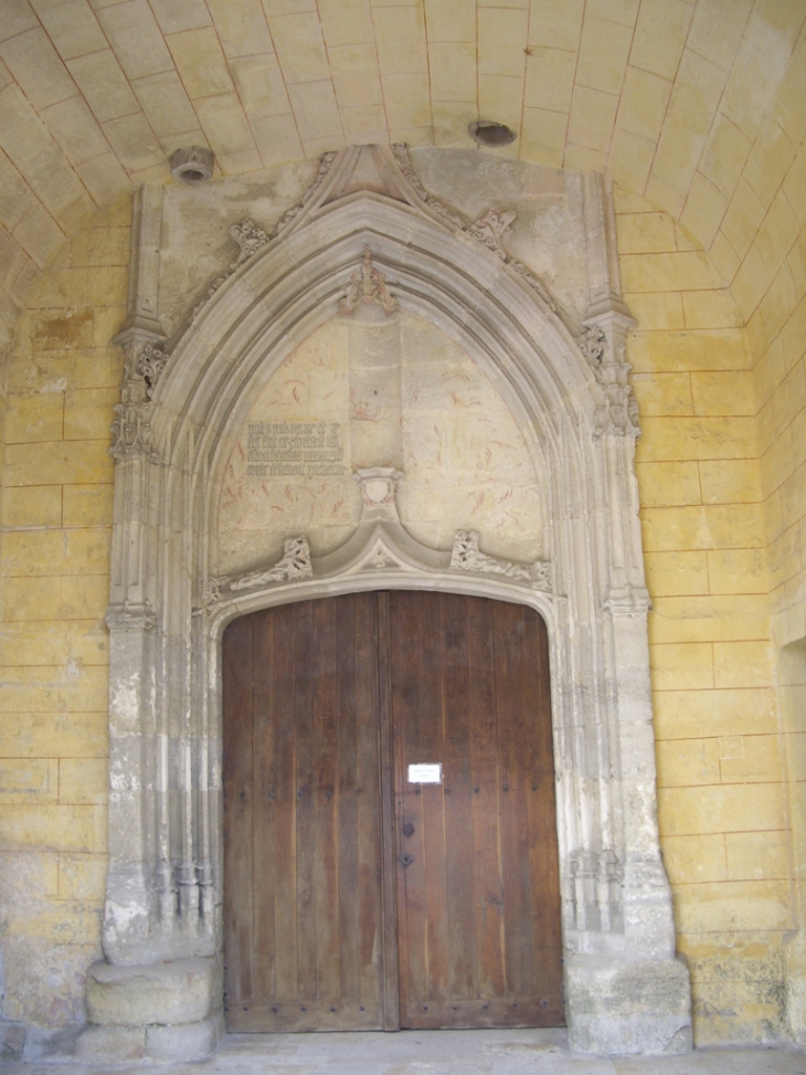 Sous le porche de l'église, le portail et son tympan avec des inscriptions de 1490. - Créon