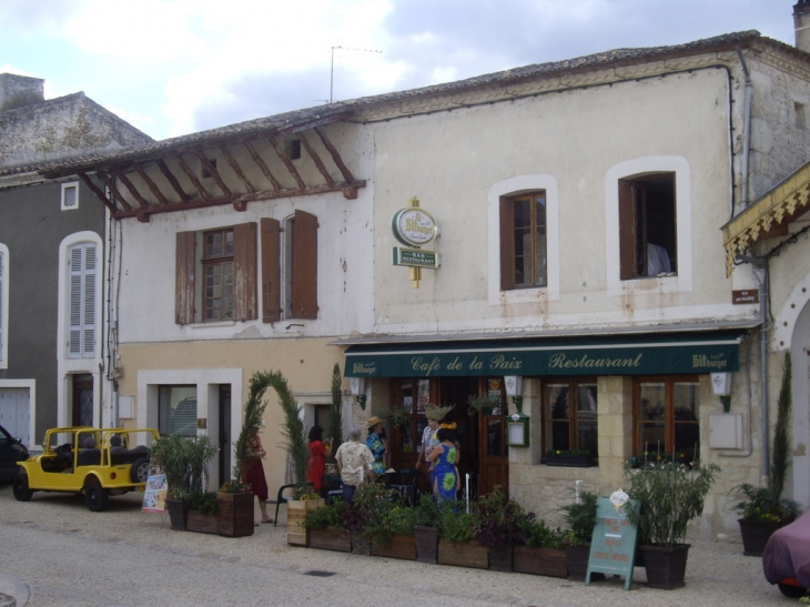 Commerce et maisons anciennes sur la place principale. - Gensac