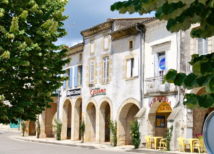 La place centrale carrée, dite place de la République, caractéristique d'une bastide est bordée d'arcades. - Sauveterre-de-Guyenne