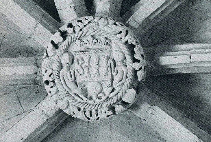 Clef de voûte intéressante : à l'intérieur d'une couronne tressée, se dressent deux personnages qui tiennent un écusson surmonté de trois fleurs de lys et orné du monogramme IHS - Eglise Saint Martin d'Esperous (photographie 1980, églises ancienne du Gar - Parleboscq