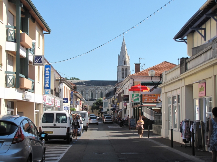 L'église eau fond d'une rue commerçante - Tartas