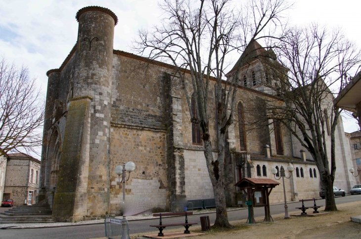 Eglise Saint-Jean-Baptiste - Façade latérale sud - La première pierre fut posée au XIe siècle. Des difficultés de financement expliquent un achèvement tardif de sa construction (XIVe siècle). c'est une église de style roman fortifiée. - Mézin