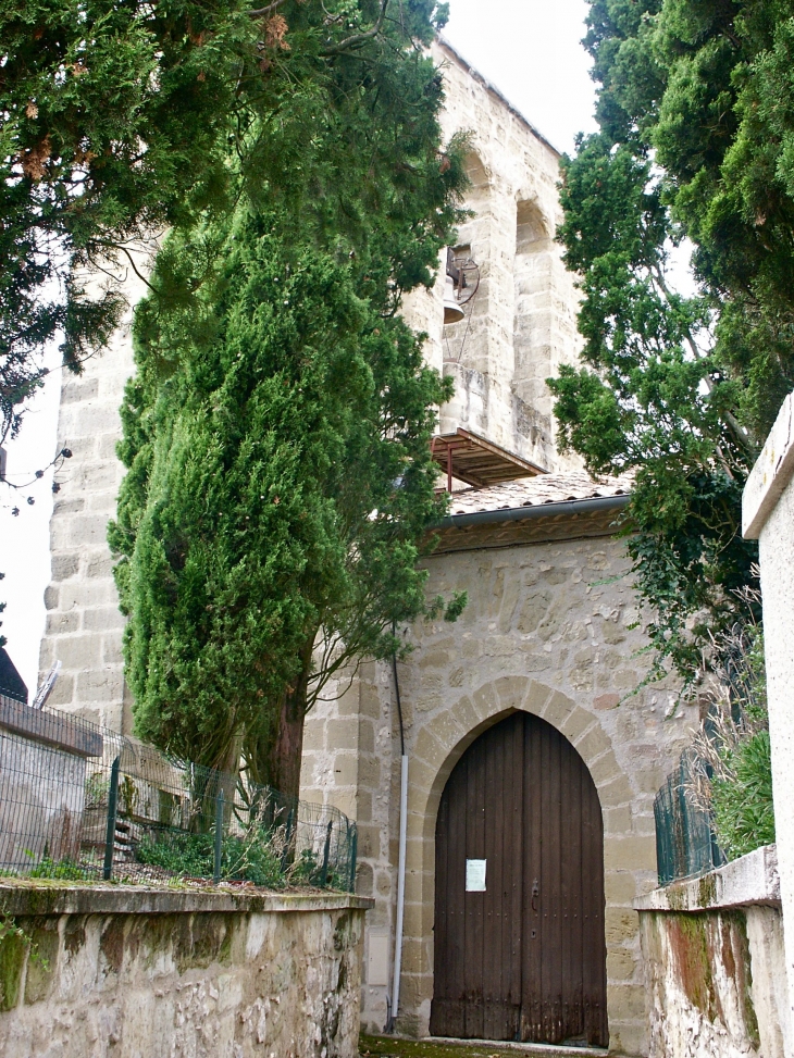 Entrée façade latérale de l'église Saint Pierre du XIIIe siècle, avec son grand clocher-peigne. - Tourtrès