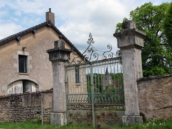 L'église vue du portail d'une maison - Pouques-Lormes