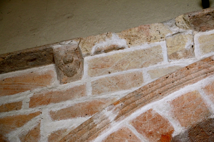 Eglise Saint Jacques : de cet ancien portail actuellement placé sous le porche du clocher subsiste une corniche à corbelets. - Fontgombault