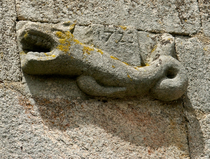 Porte de la sacristie surmontée d'une sculpture figurant un animal fantastique (animal marin). - Chaumeil