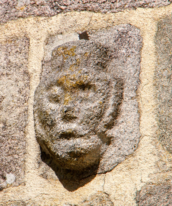 Pierre sculptée incrustée dans le mur de l'église. - Chavanac
