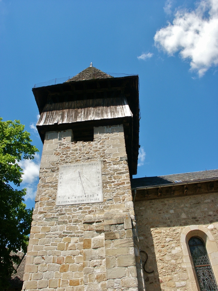 Le clocher-tour de l'église romane est coiffé d'un bourdage en bois et donne une allure guerrière à l'ensemble du bâtiment. - Saint-Chamant