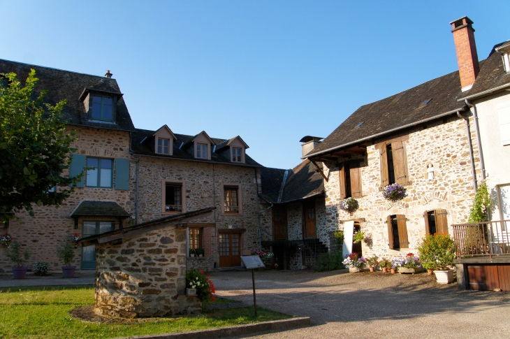 Le puits et les maisons anciennes près de l'abbatiale. - Vigeois