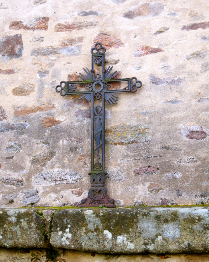 Petite croix contre la façade nord de l'église Saint Sulpice. - Dournazac