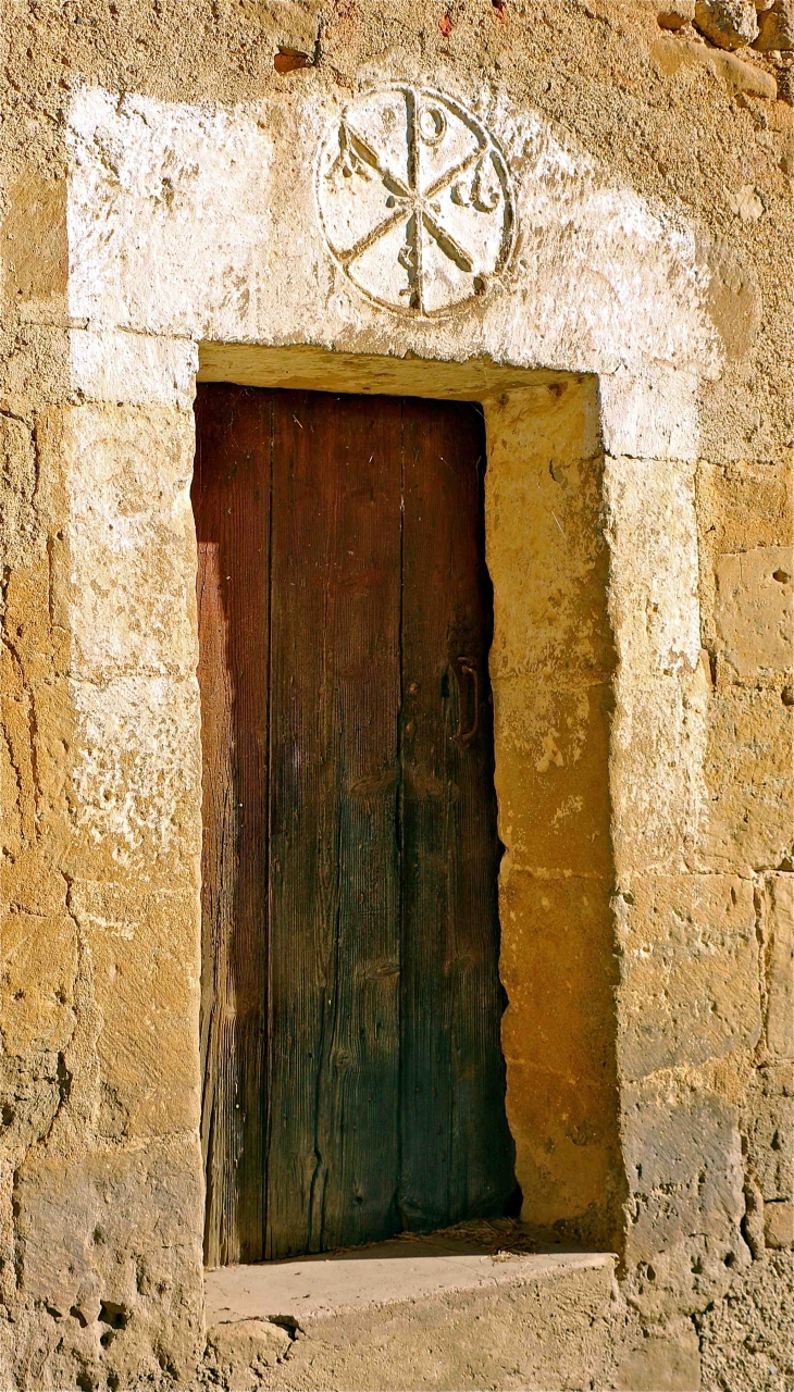 Eglise Romane Saint Michel: petite porte de la façade Sud avec son ancien Chrisme roman - Lamaguère