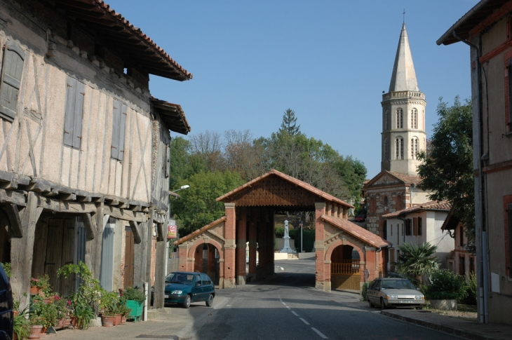 Le coeur de village, avec le RD626 qui passe sous la halle - Montpézat