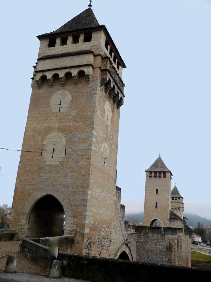 Le Pont Valendré est flanqué d'avant-becs crénelés et surmonté de trois tours carrées à créneaux et mâchicoulis dominant l'eau de 40 mètres. - Cahors