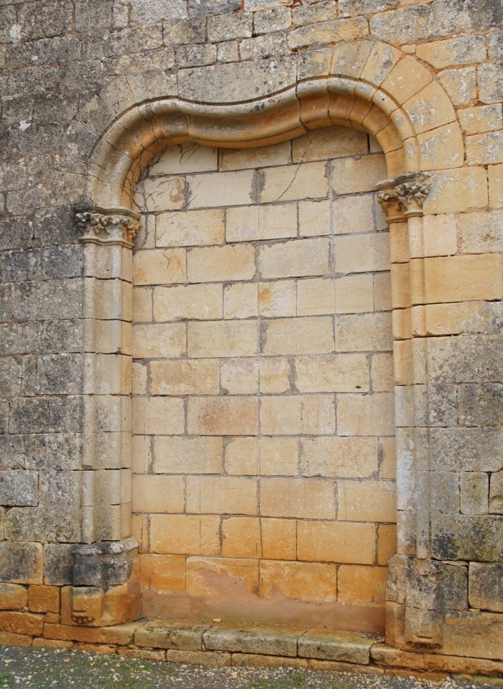 Eglise Saint Louis : une curieuse porte latérale ornée d'un arc ployé en contrecourbe. - Montcabrier