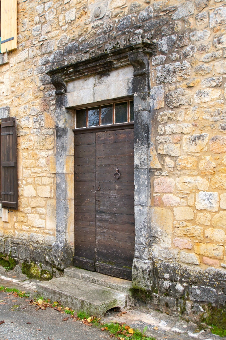 Dans le village, porte ancienne avec la Coquille au-dessus du linteau. - Montcabrier