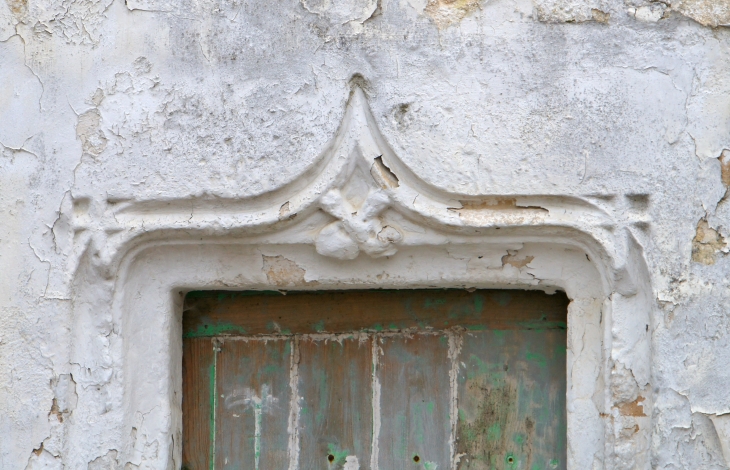 Linteau sculpté d'une ancienne maison du village, près de l'église Saint André. - Clion