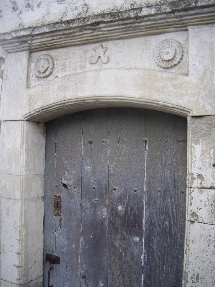 Linteau sculpté d'une maison ancienne. - Léoville