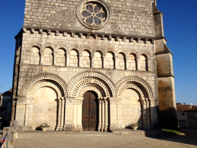 Façade romane de l'église à chapiteaux sculptés, corniches à modillons et métopes. - Saint-Fort-sur-Gironde