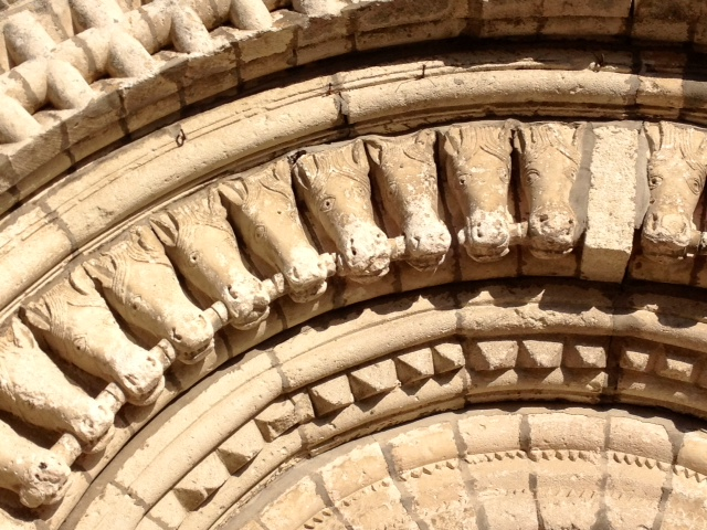 Détail du portail et sa voussure ornée de têtes de chevaux. - Saint-Fort-sur-Gironde