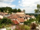 Les Falaises calcaires surplombent les toits du village. Au fond le château.