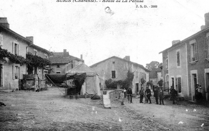 Un marchand ambulant sur la place, devant l'ancienne boucherie vers le début du XX ème siècle - Suris