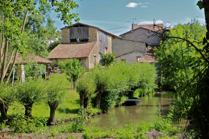 Au nord, le quartier de la Garenne est remarquable pour ses fermes à double accès qui s'étirent le long du bief Minet. - Arçais