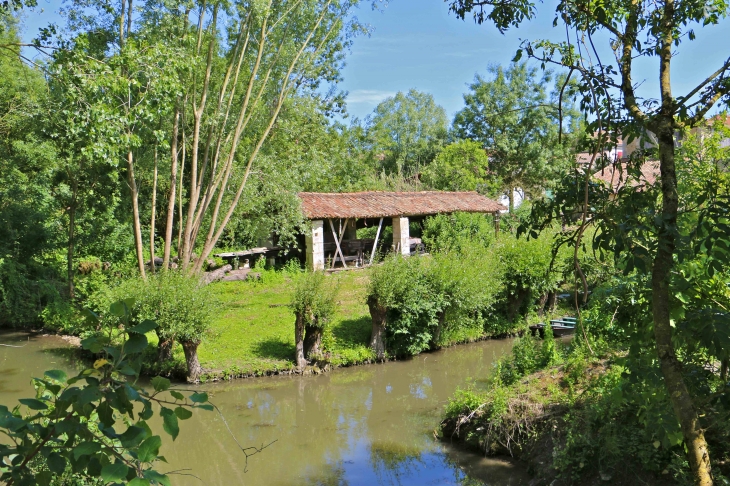 Au nord, le quartier de la Garenne est remarquable pour ses fermes à double accès qui s'étirent le long du bief Minet. - Arçais