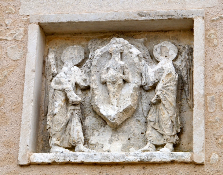 Pierre du XIIe siècle. Ce remploi, inséré à une date inconnue sur le mur extérieur du transept, représente un personnage nu, symbolisant une âme, inscrit dans une mandorie soutenue par deux anges. - Saulgé