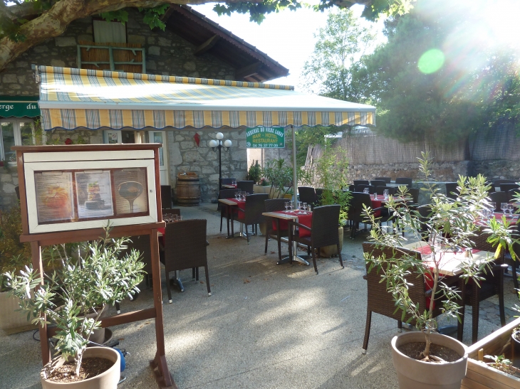 La place du village avec la terasse le l'auberge du vieux Lanas, hotel restaurant en ardèche