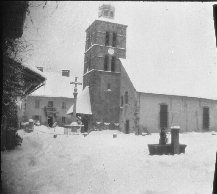 L'église sous la neige une femme fait le plein d'eau - Morillon